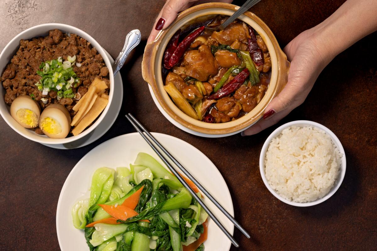 A spread of dishes including minced pork on rice, three-cup chicken with rice, and sauteed seasonal vegetables