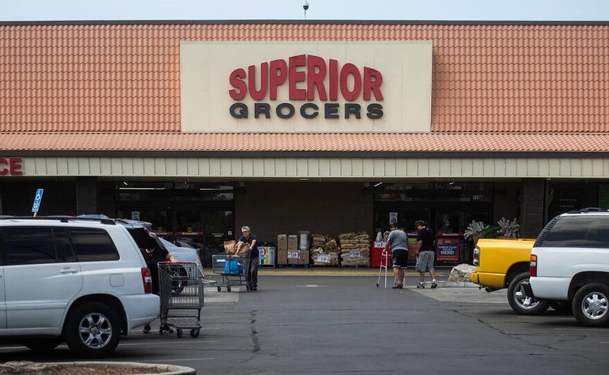 People walk through the parking lot of Superior Grocers in Tulare on April 16, 2026.