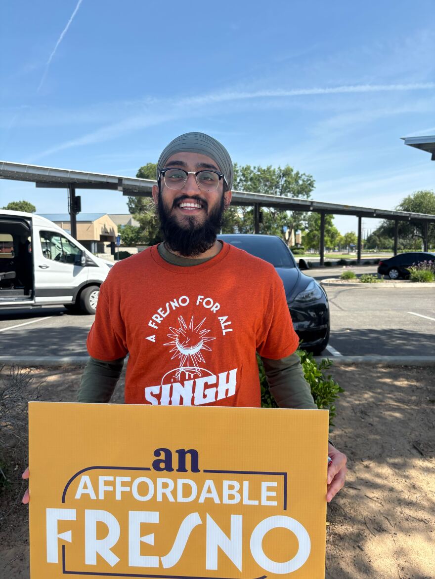 Harman Singh, wearing an orange T-shirt, carrying in his hands a yellow poster with the message: "An Affordable Fresno," at a march for one of the candidates for the Fresno City Council on May 2, 2026.