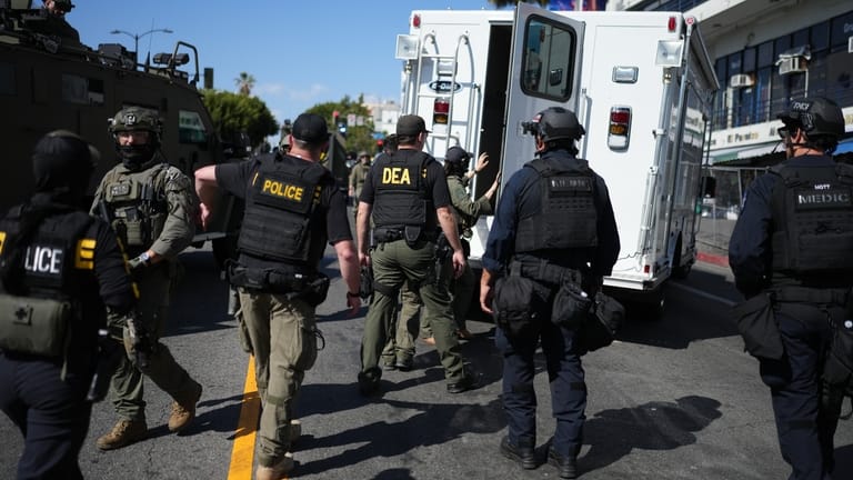 Drug Enforcement Administration (DEA) agents alongside other law enforcement officers...