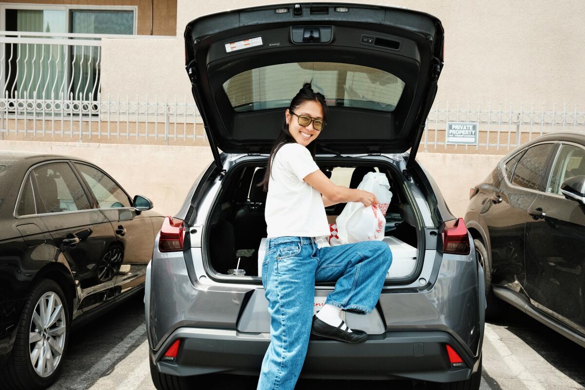 Kelsey Lee of Dover Sole Market holds plastic bags containing poke in the back of her car