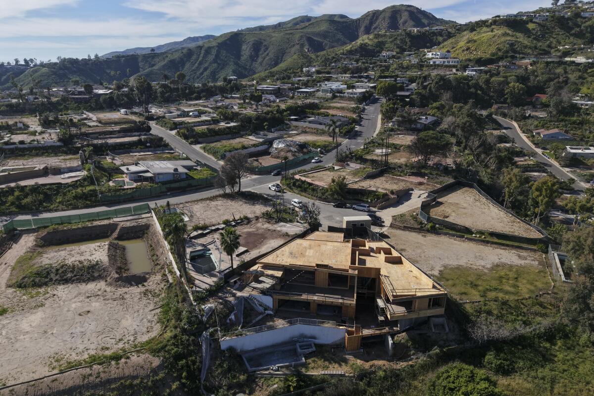 A home under construction is surrounded by empty lots.