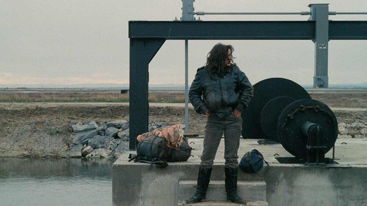 A woman stands outdoors.