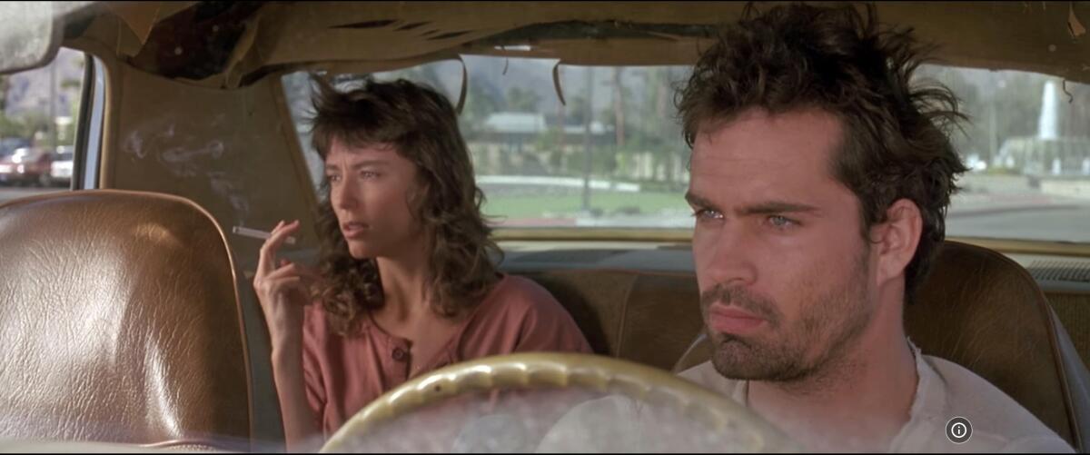 Two exhausted people drive in a car.