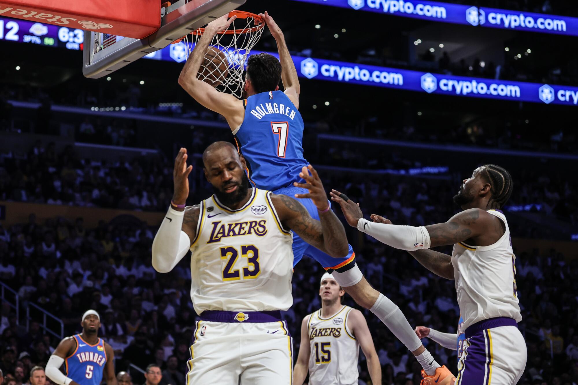 Lakers forward LeBron James, center, shows frustration as Thunder center Chet Holmgren, left, slam dunks during Game 3.