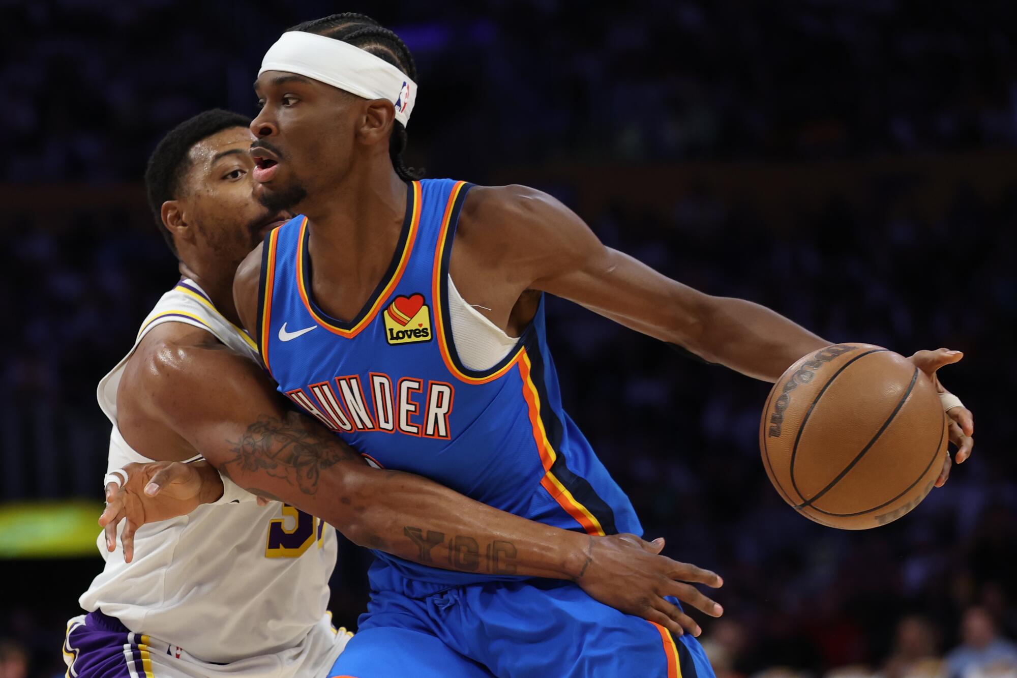 Lakers guard Marcus Smart reaches with his right arm to try to steal the ball from Thunder guard Shai Gilgeous-Alexander.