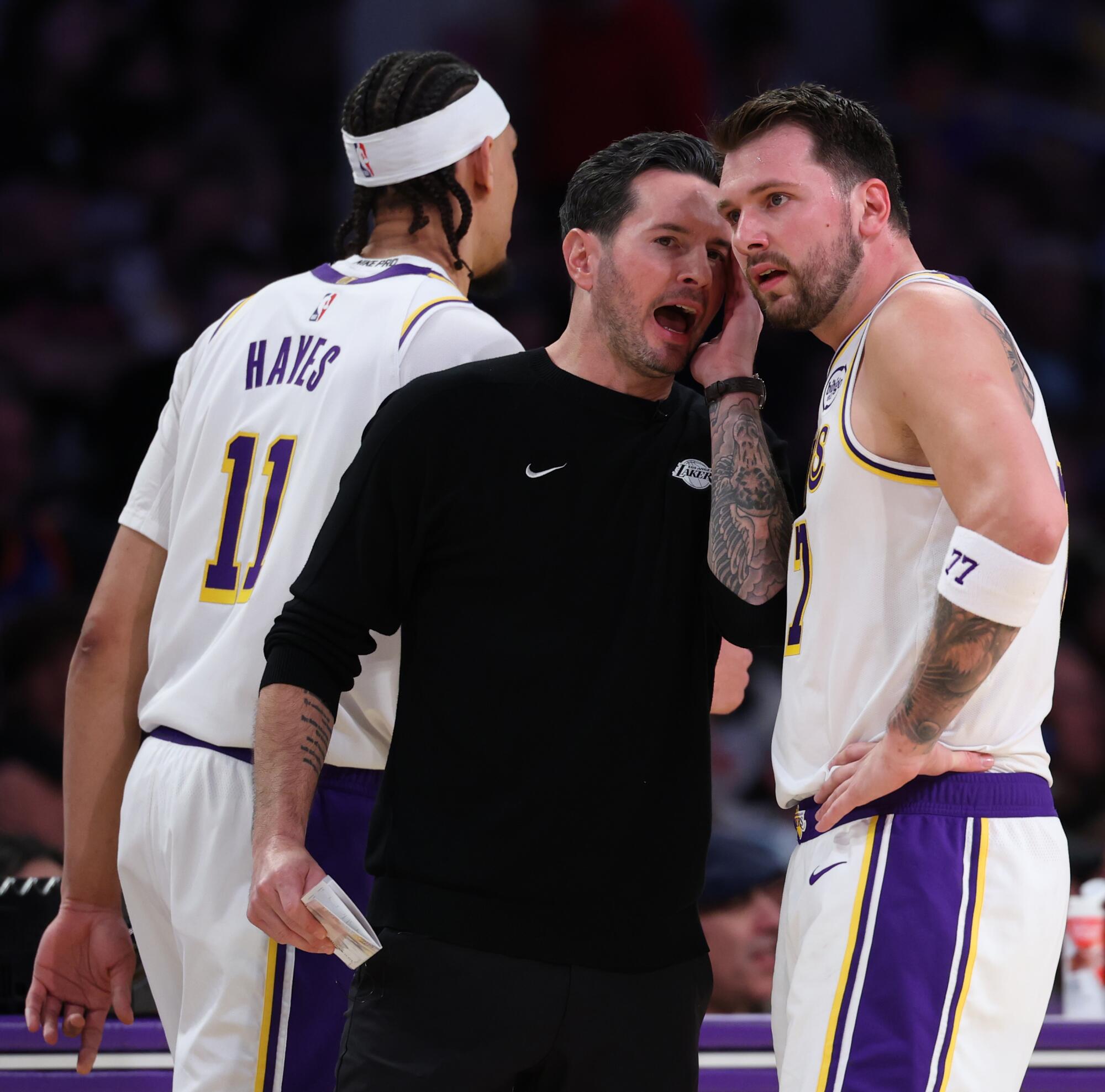 Lakers coach JJ Redick gives instructions to guard Luka Doncic during a game in March.
