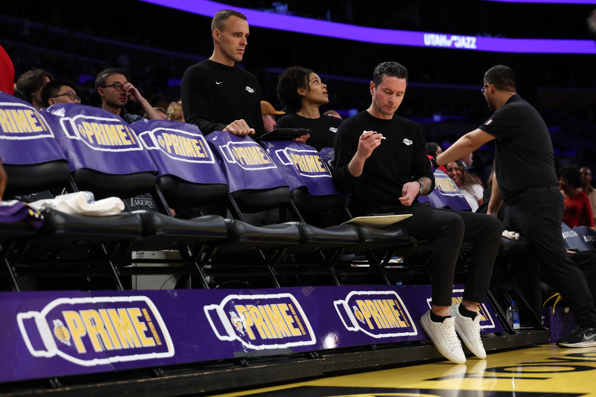 Lakers coach JJ Redick reviews his notes during a solitary moment on the bench before a game against the Utah Jazz in April.