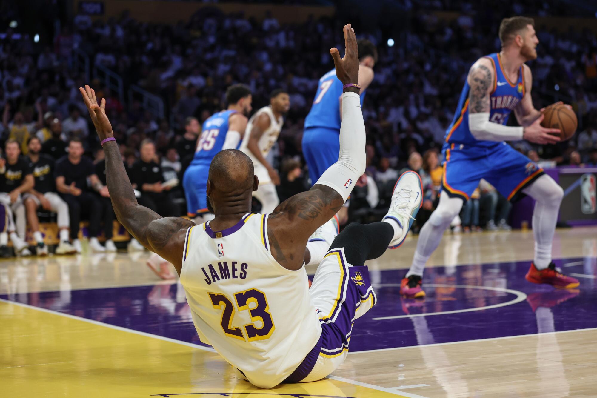 Lakers forward LeBron James, sliding backward across the baseline, looks for a foul call  on a missed layup during Game 3.
