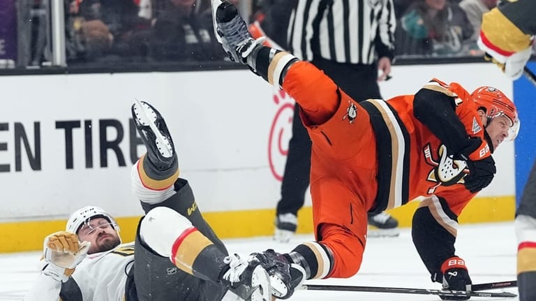 Anaheim Ducks' John Carlson (74) is tripped up by Vegas...