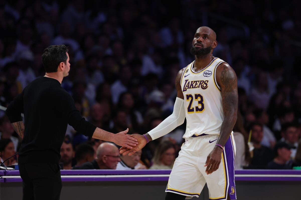 Lakers star LeBron James slaps hands with coach JJ Redick on his way to the bench.