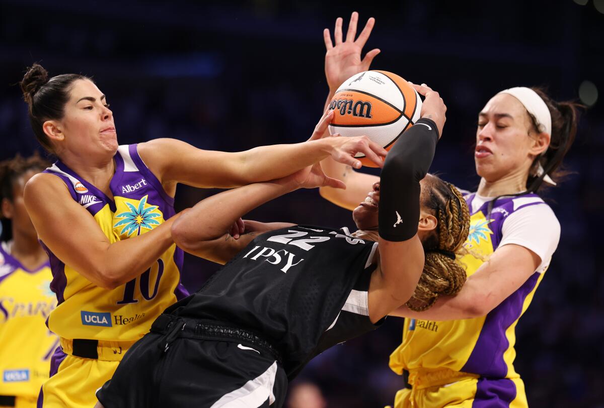 Sparks guard Kelsey Plum, left, and forward Dearica Hamby, right, battle Las Vegas center A'ja Wilson.