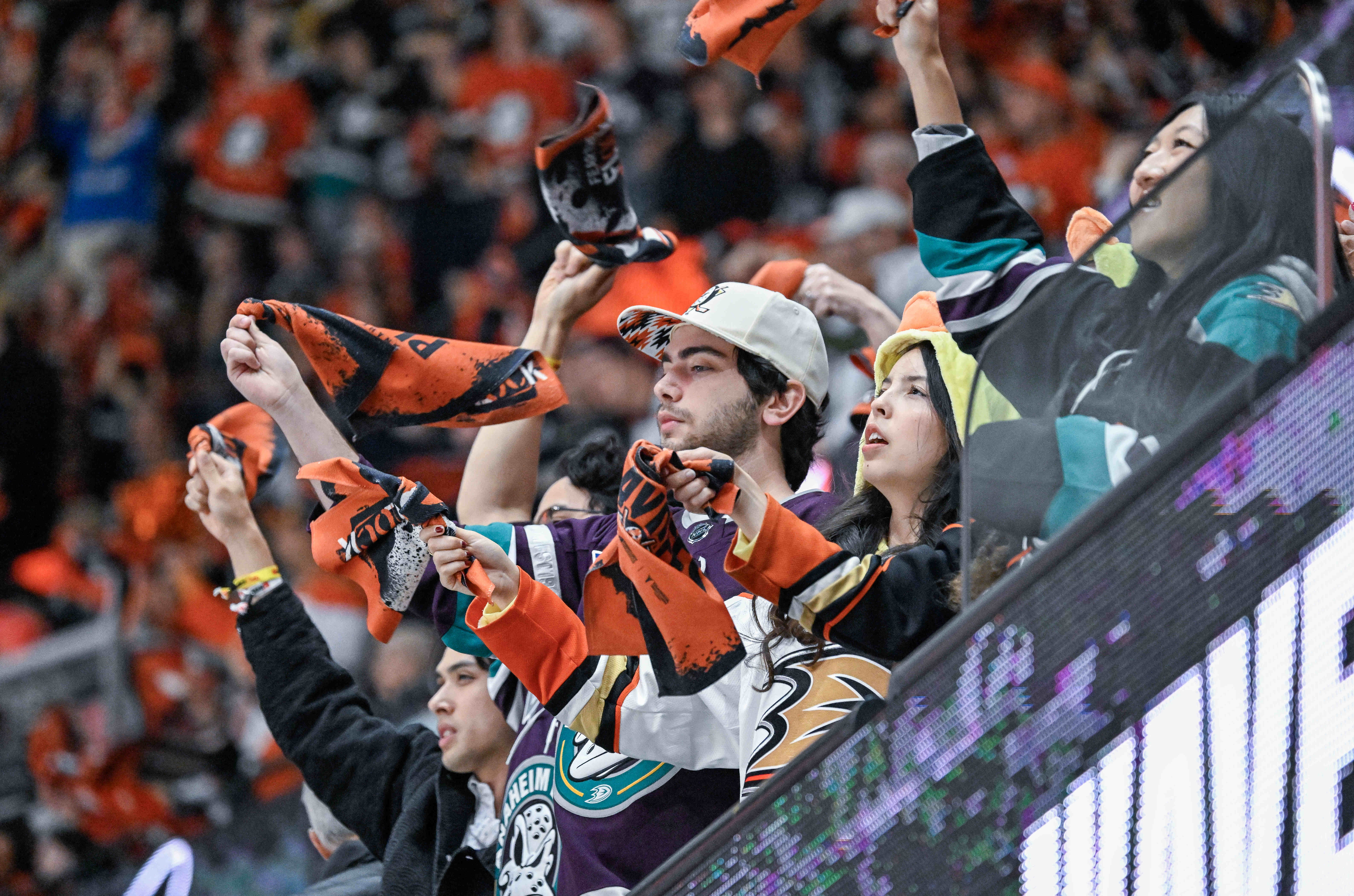 Ducks fans wave towels in the air as they chant...