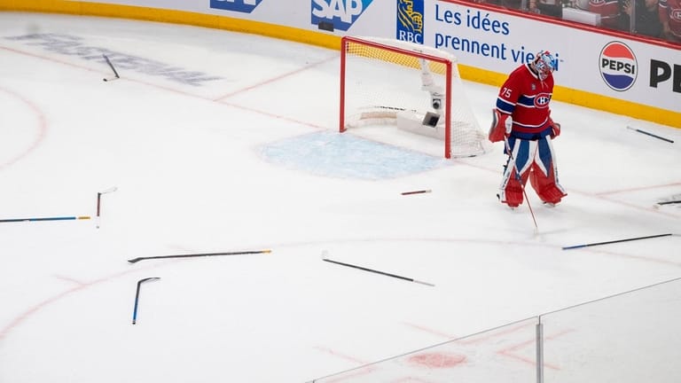 Montreal Canadiens goaltender Jakub Dobes (75) looks at hockey sticks...