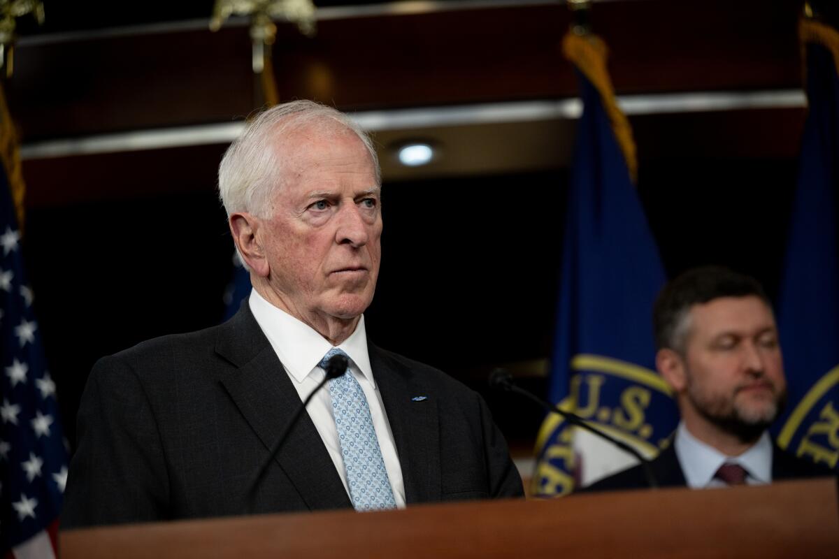 A man in a suit at a lectern.