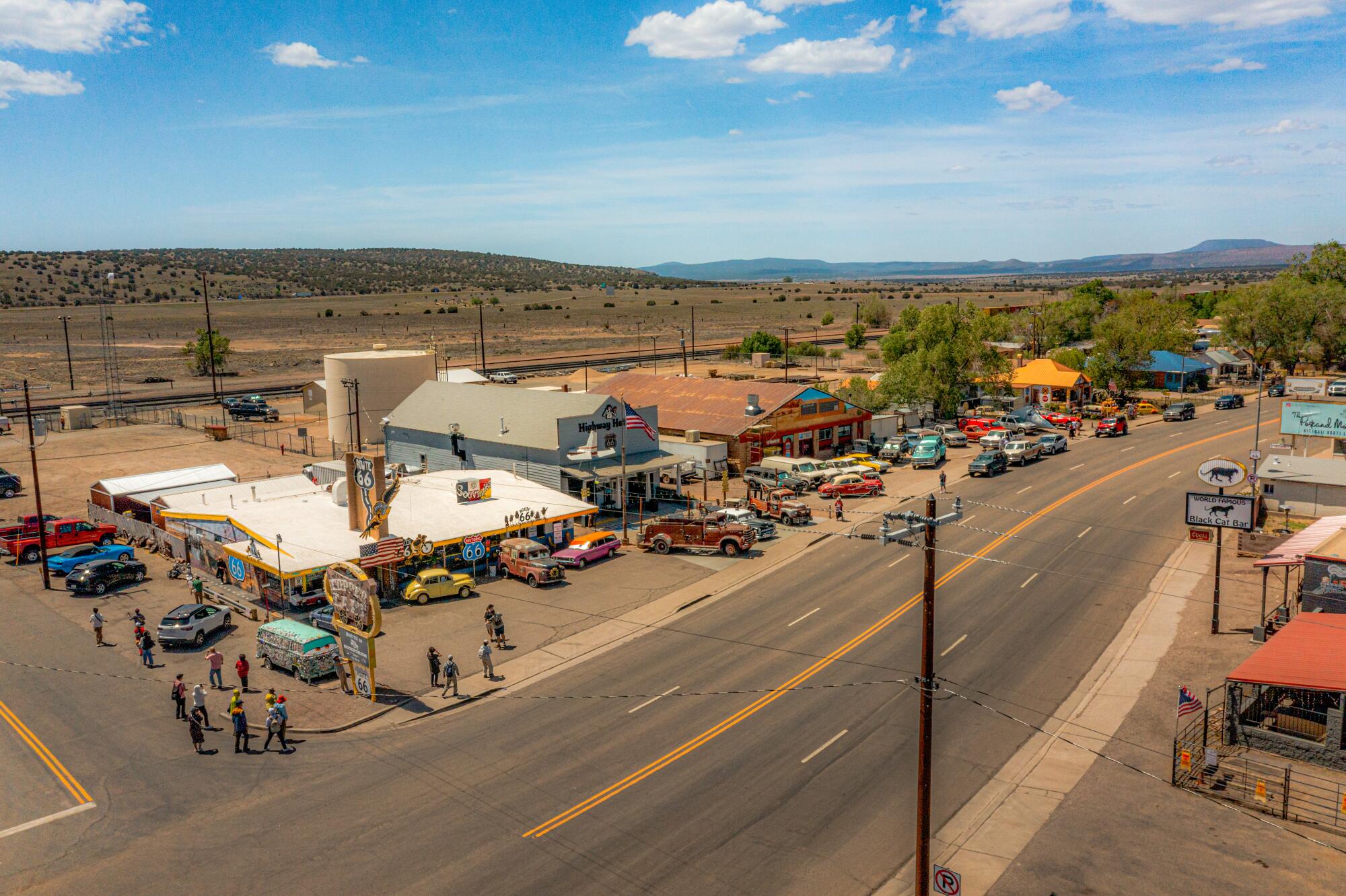 A small collection of roadside shops along a dusty Route 66 road. 