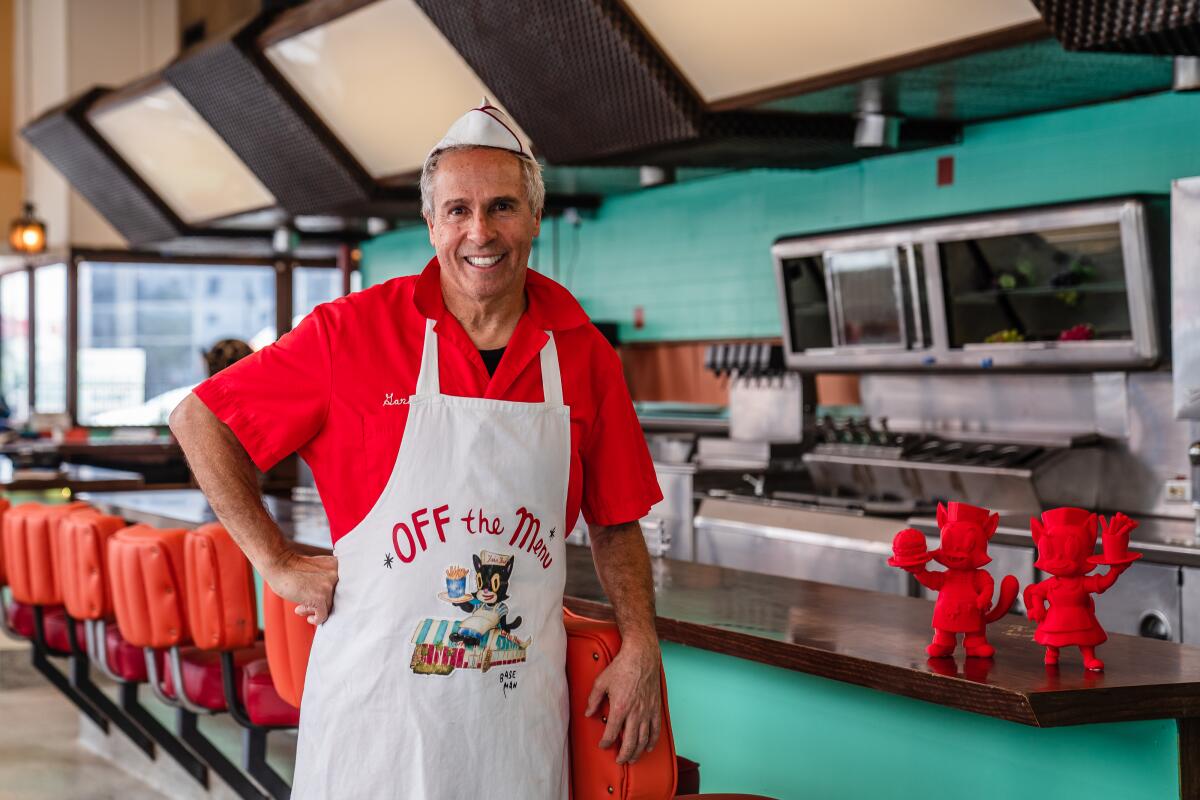 Gary Baseman stands next to a diner counter.