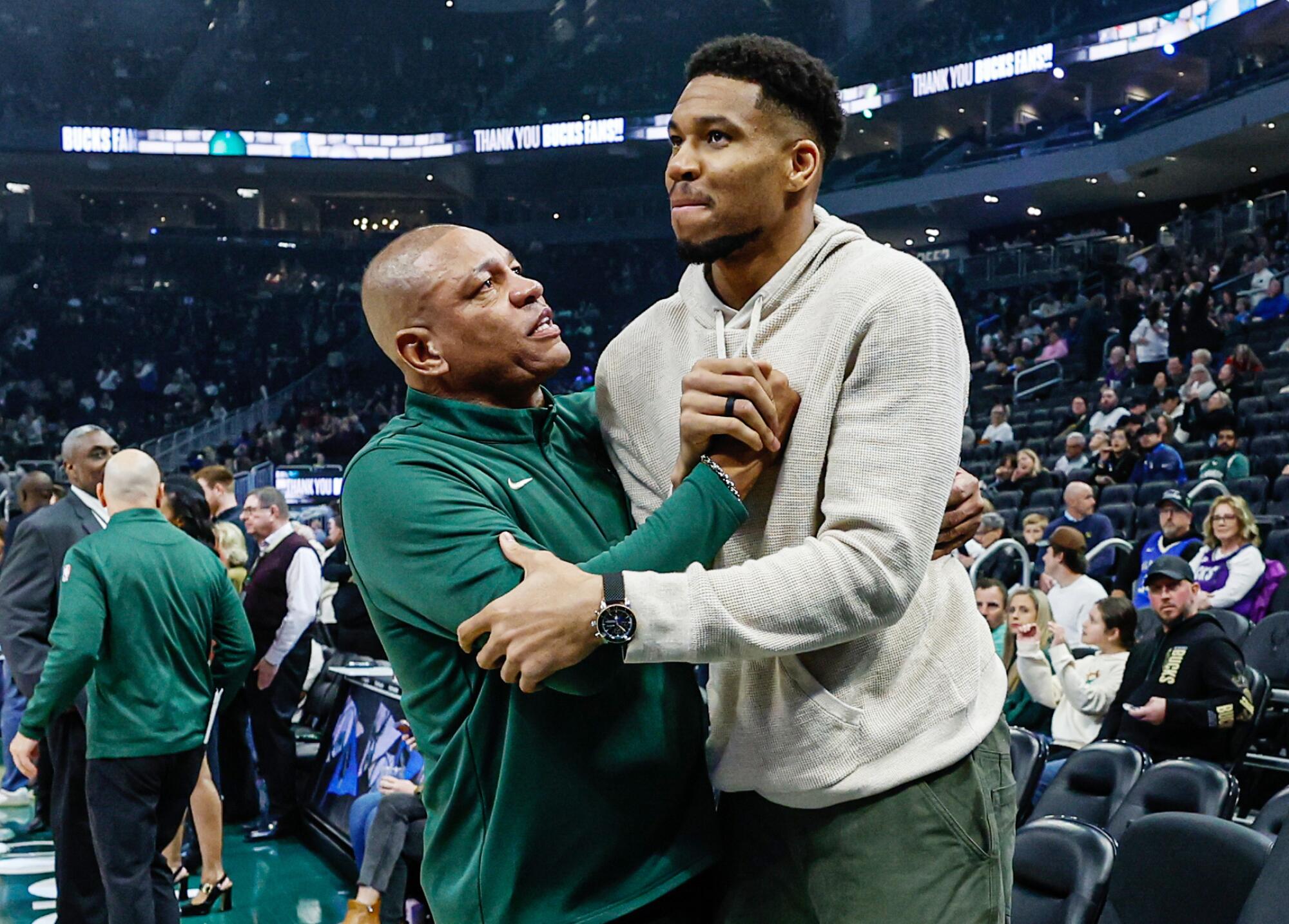 Bucks coach Doc Rivers, left, and Giannis Antetokounmpo, right, embrace before a game this season.