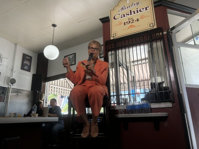 Woman in chair wearing salmon pants suit