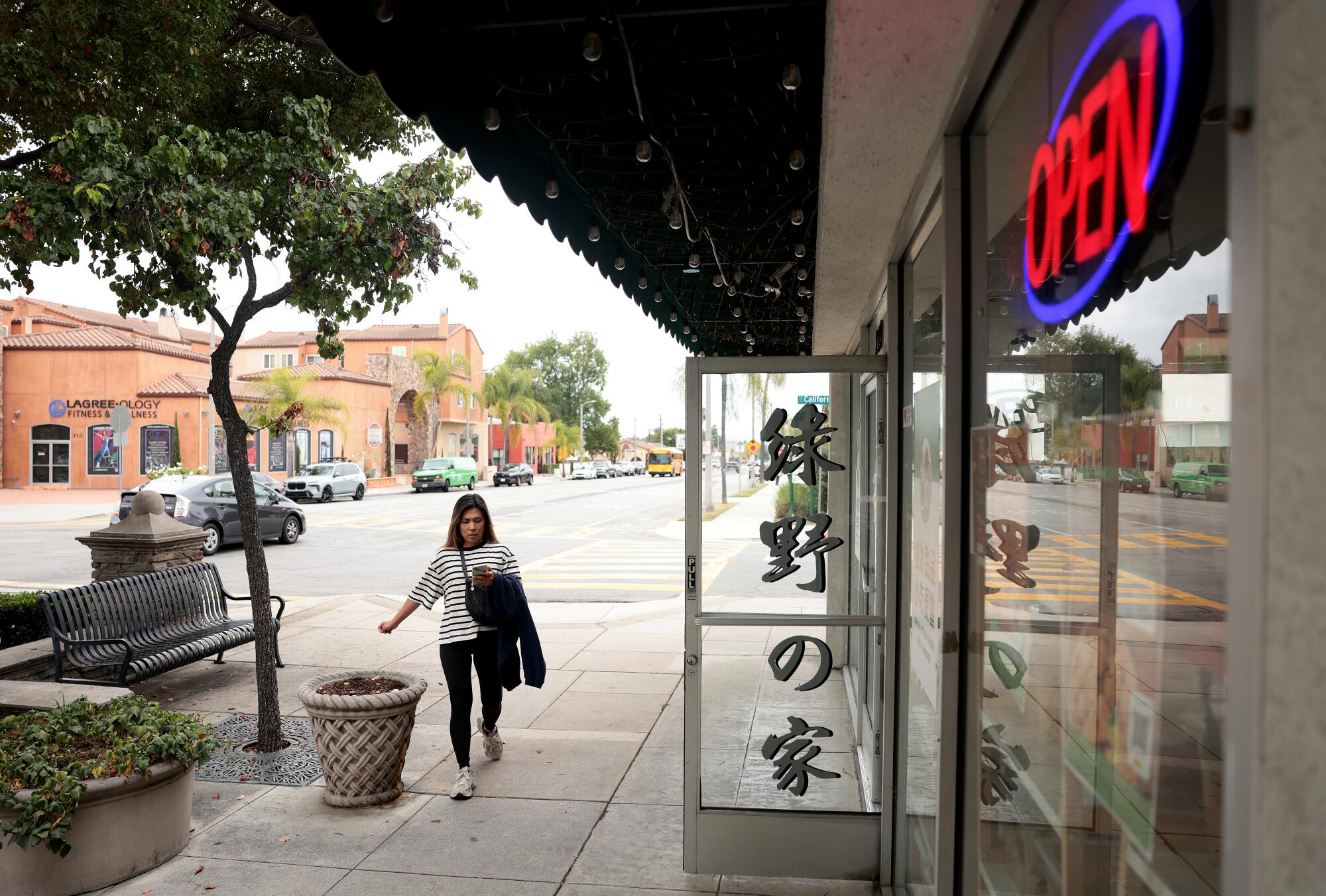 A pedestrian walking by a restaurant in downtown Arcadia