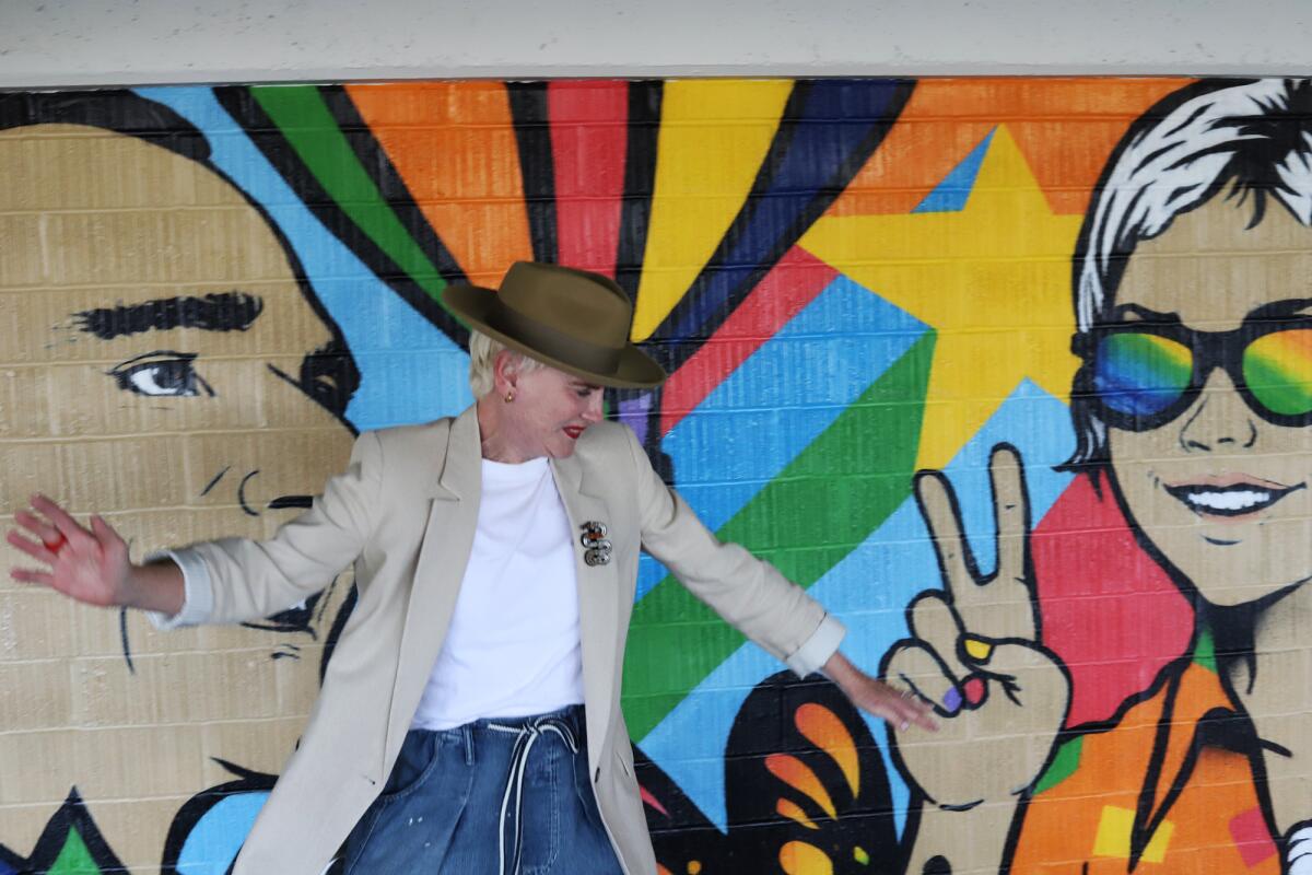 Donna McNutt a City of Hope cancer survivor dances by the mural "The Long Run" by the artist known as Bumble Bee Loves You.