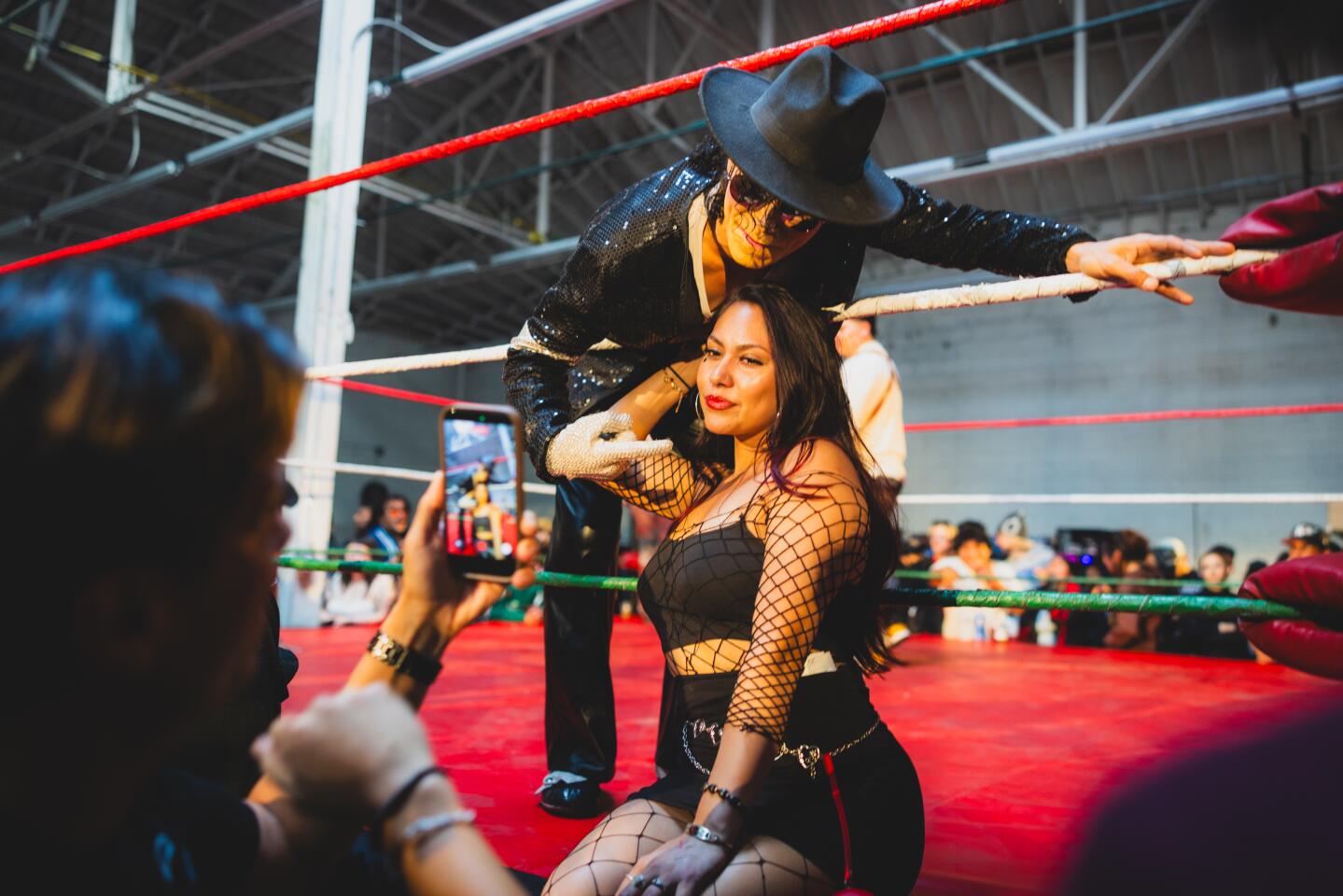 Darlene Cabrera poses with Santana Jackson, a Michael Jackson impersonator and fighter at the the Lucha Experience.