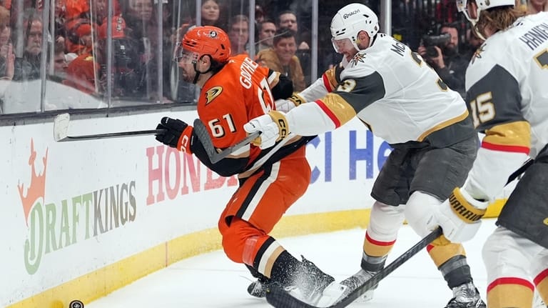 Anaheim Ducks' Cutter Gauthier (61) is cross checked by Vegas...