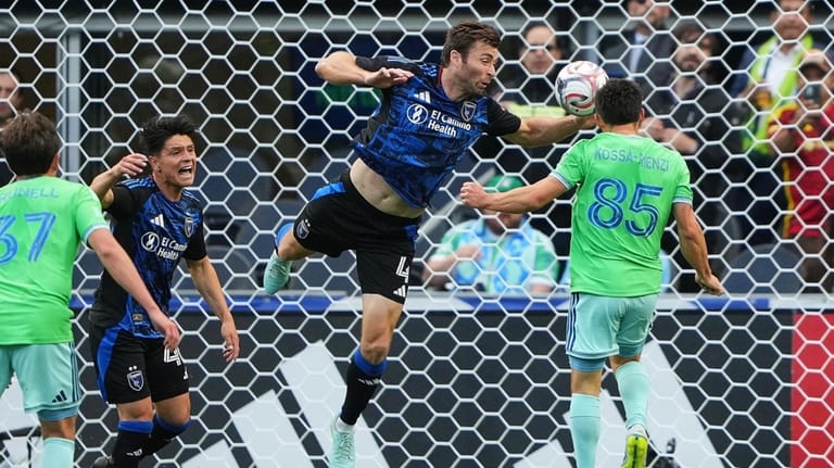 San Jose Earthquakes defender Dave Romney, center, commits a handball...