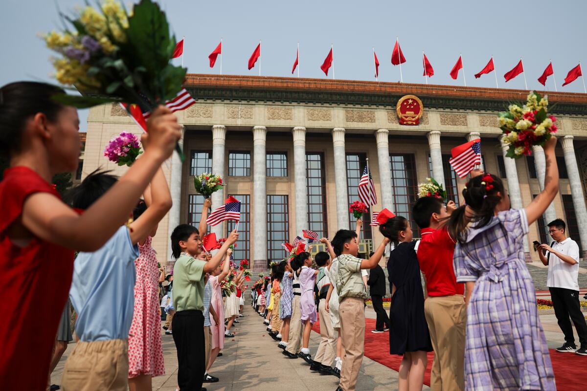 Children holding Chinese and U.S. flags rehearse before the welcome ceremony for President Trump.