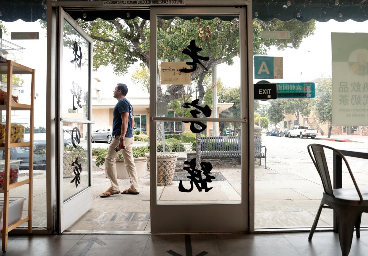 A pedestrian passes by a restaurant in downtown Arcadia