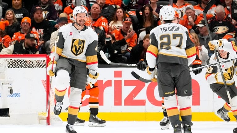 Vegas Golden Knights defenseman Shea Theodore, right, celebrates his goal...