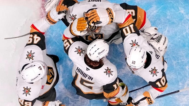 Vegas Golden Knights goaltender Carter Hart, top, is congratulated by...