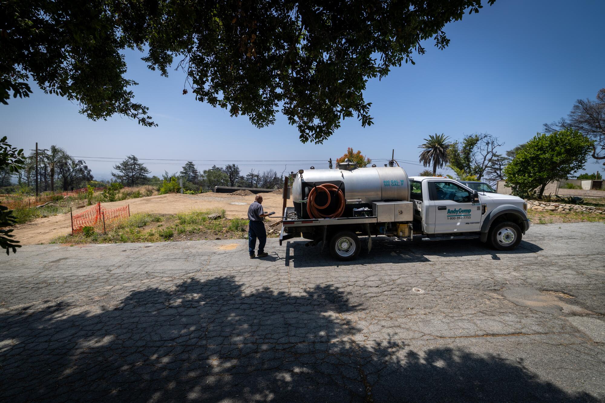 A worker pumps the sewage from a portable toilet in Altadena on May 1, 2026.