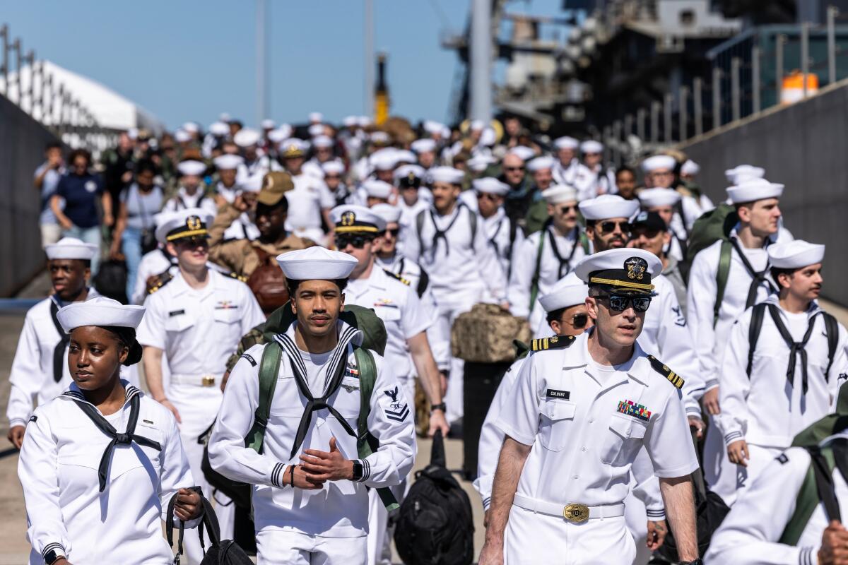 Sailors walk disembarking from the USS Gerald R. Ford