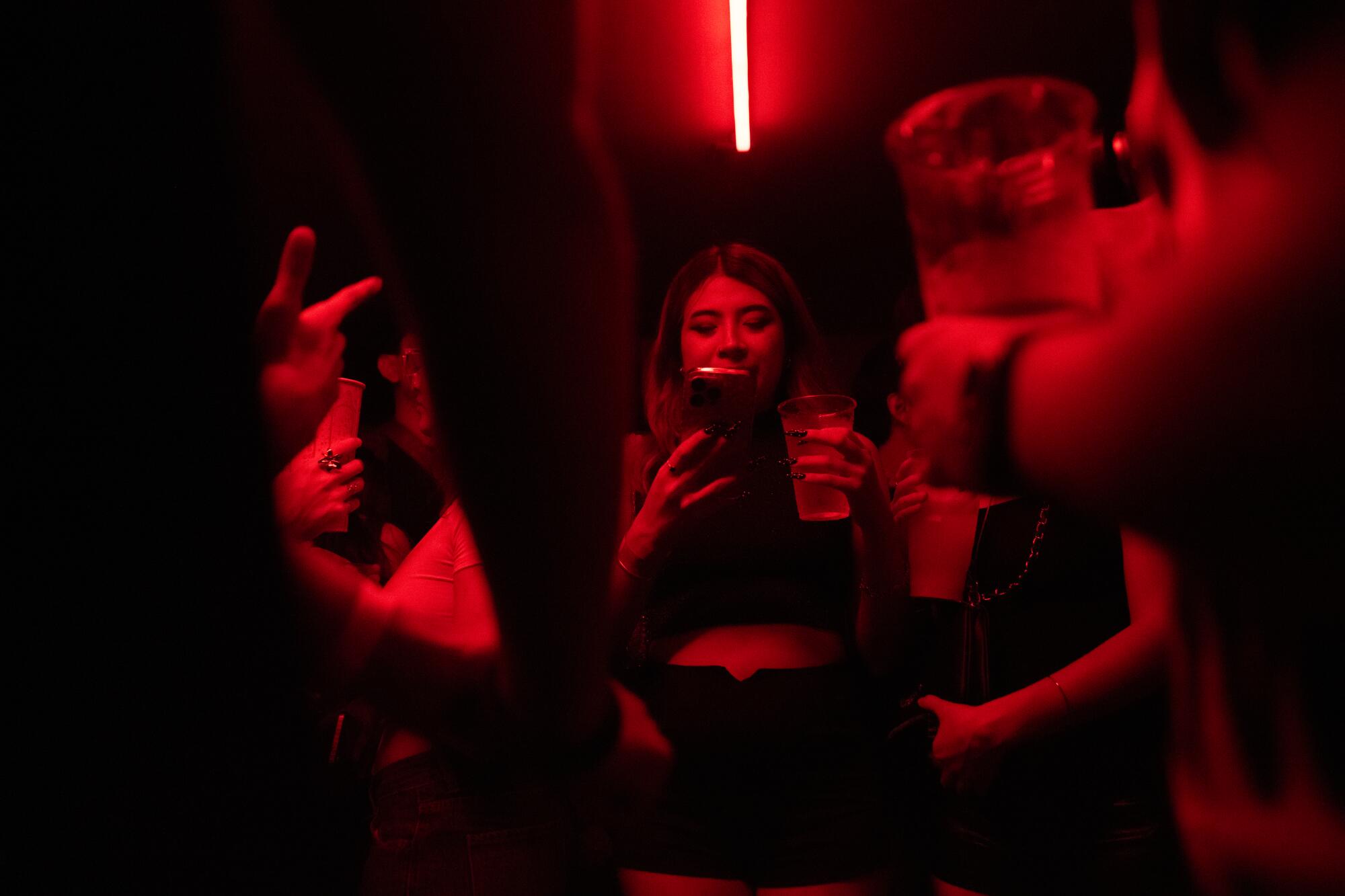 Mexico City, Mexico - May 15, 2026: A woman checks her phone on the dance floor