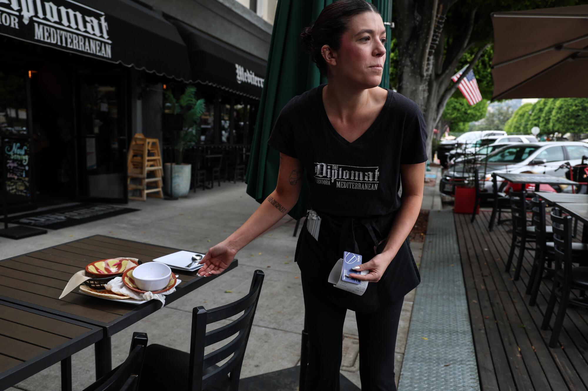 A waitress places food on the table at a Glendora restaurant
