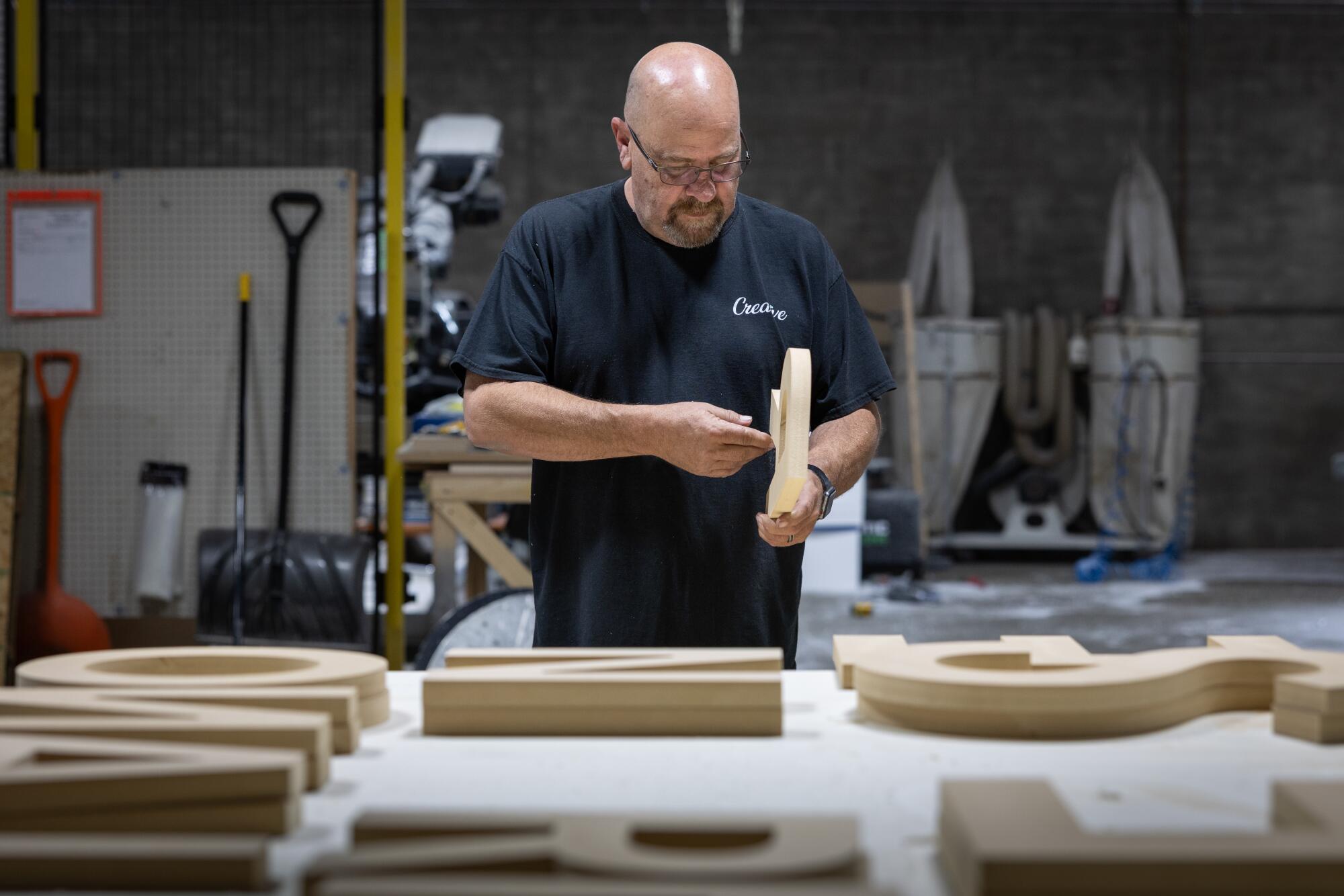 A man examines woodwork in a shop