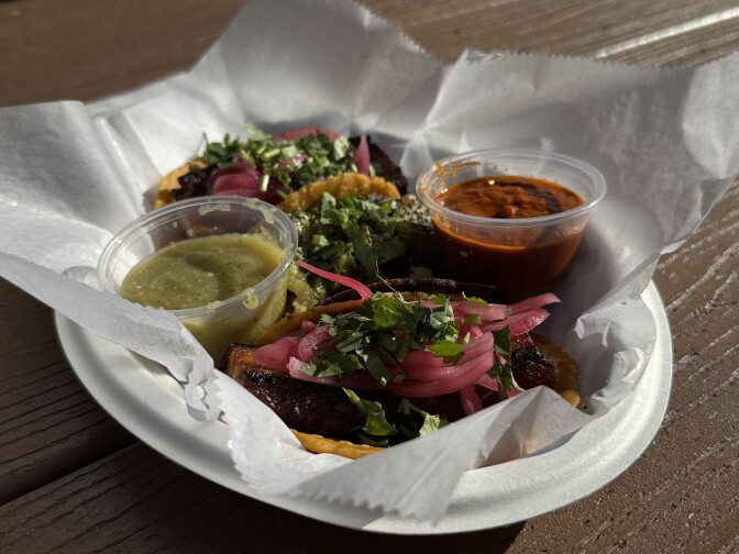 A plate of tacos with salsa.