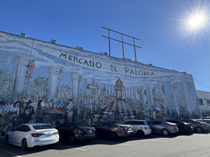 Exterior of a building that says "Mercado La Paloma." The building's facade features a mural of people making food and dining.