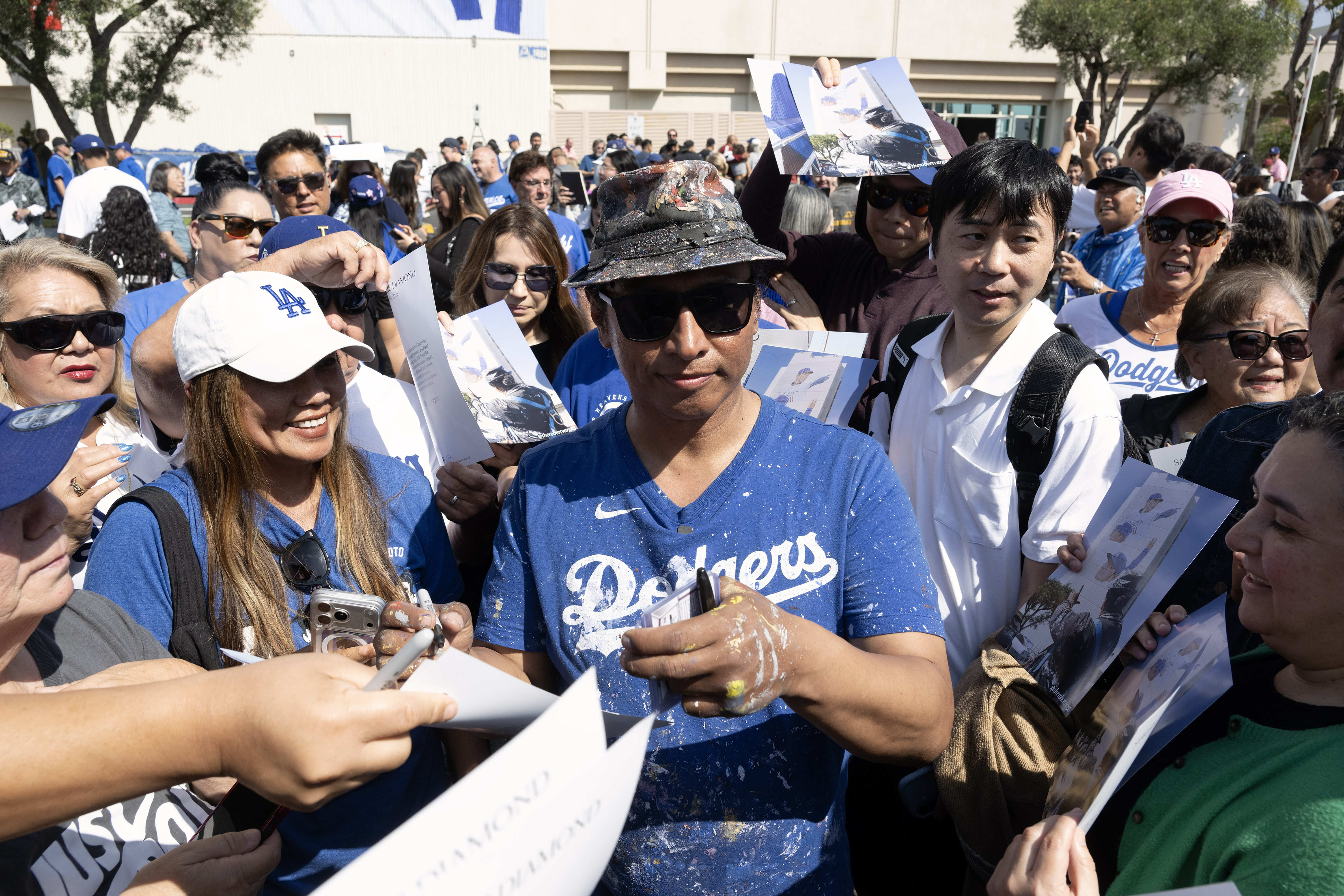 Artist Robert Vargas signs autographs during the unveiling ceremony for...