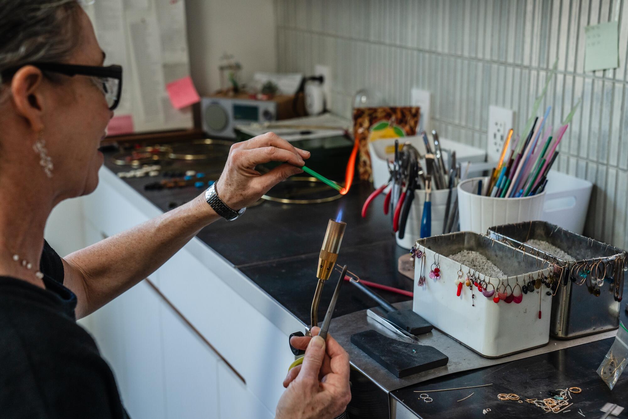 Burton melts glass for jewelry with a plumbing torch.