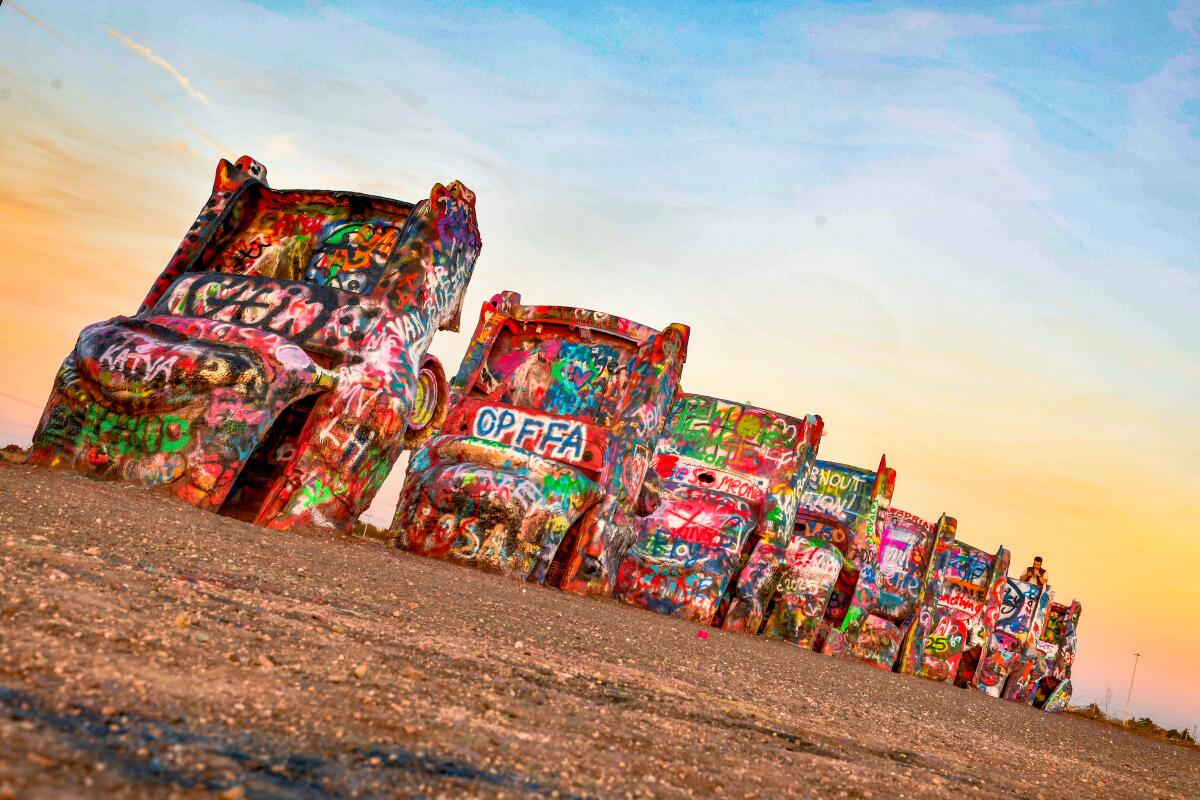 An art installation in Amarillo, TX, where 10 Cadillacs are half-buried in the ground