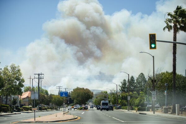 The Sandy Fire sends a plume of smoke in the air on Monday, May 18, 2026, in Simi Valley, Calif. (AP Photo/Ethan Swope)