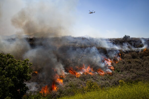 The Sandy Fire burns vegetation on Monday, May 18, 2026, in Simi Valley, Calif. (AP Photo/Ethan Swope)