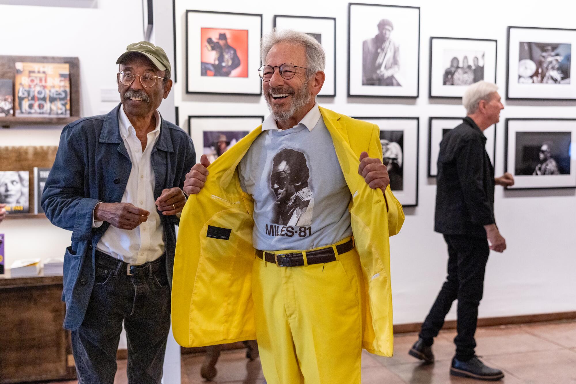 Tom Copi, wearing all yellow, and Bruce Talamon, left, pose together for a photo at Musichead Gallery.