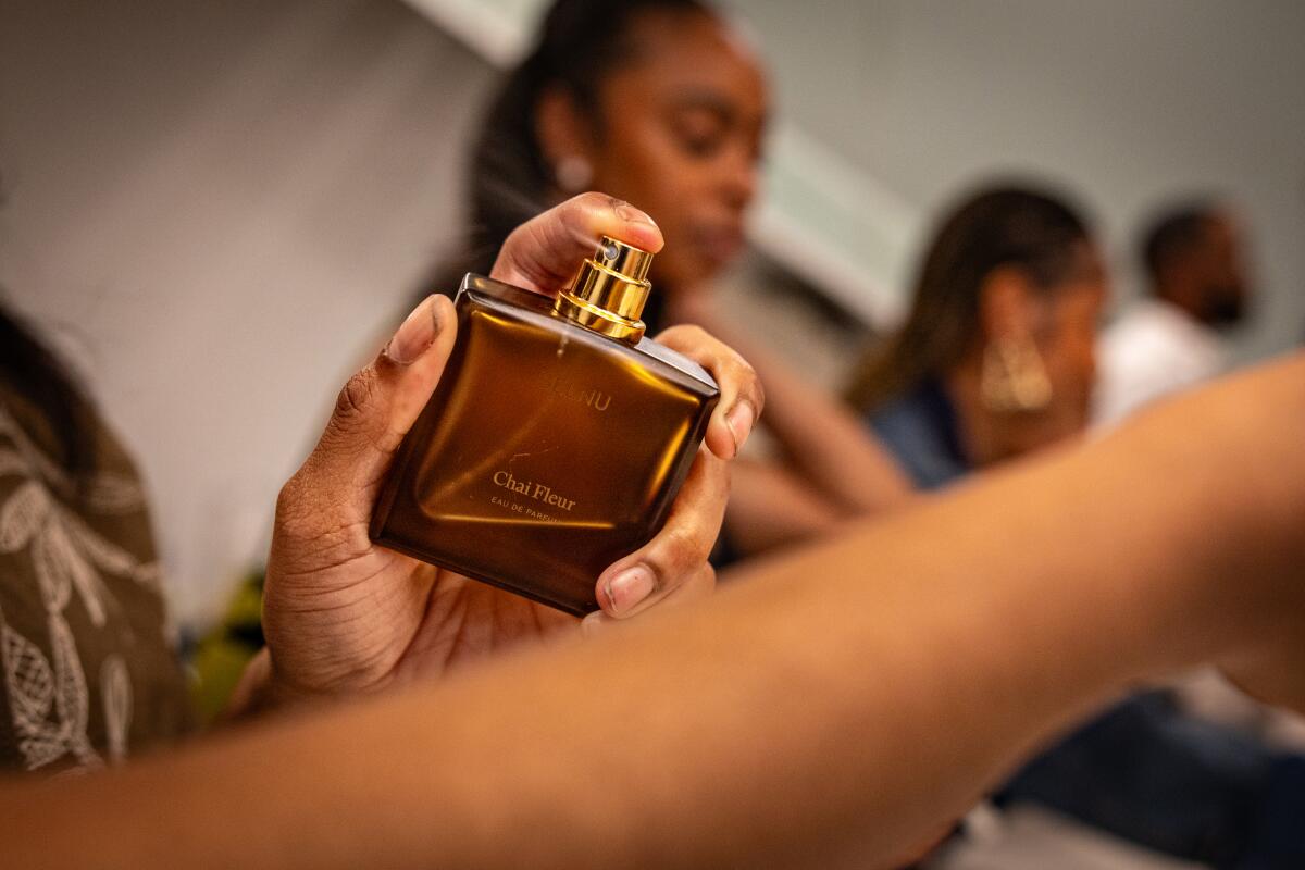 Detail photo of Jess Blaise testing out a bottled scent by Selnu on her wrist.