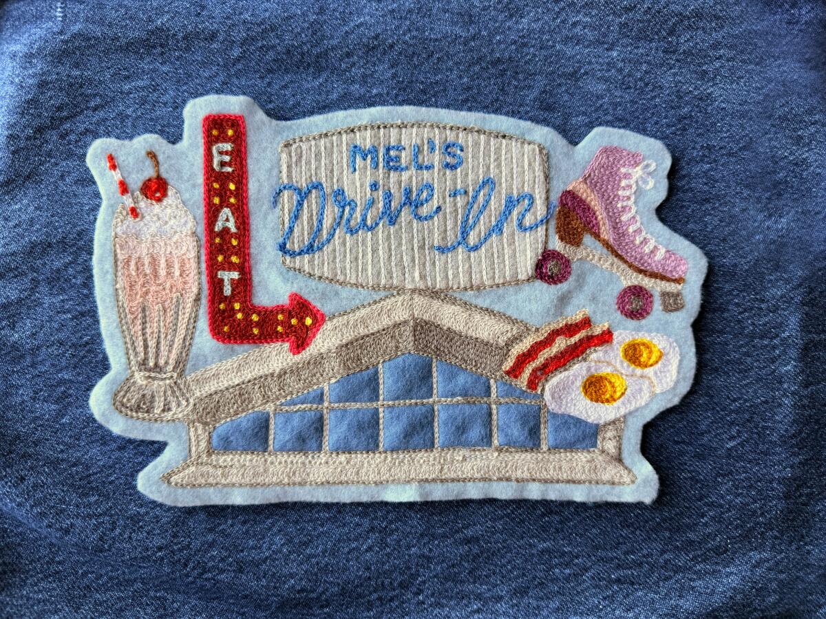 Embroidered patch with rendering of Mel's Drive-In sign and restaurant, milkshake, rollerskate and breakfast