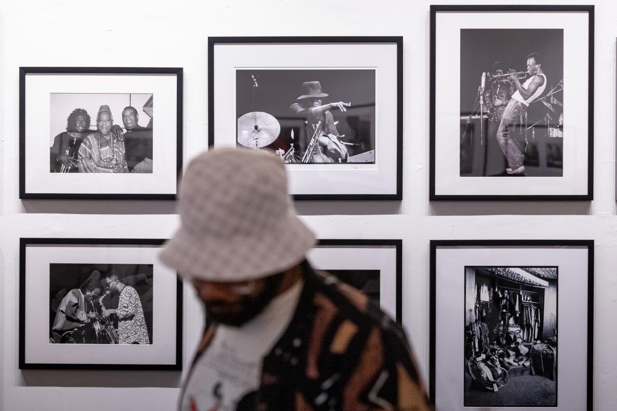 A person in front of photos on a wall