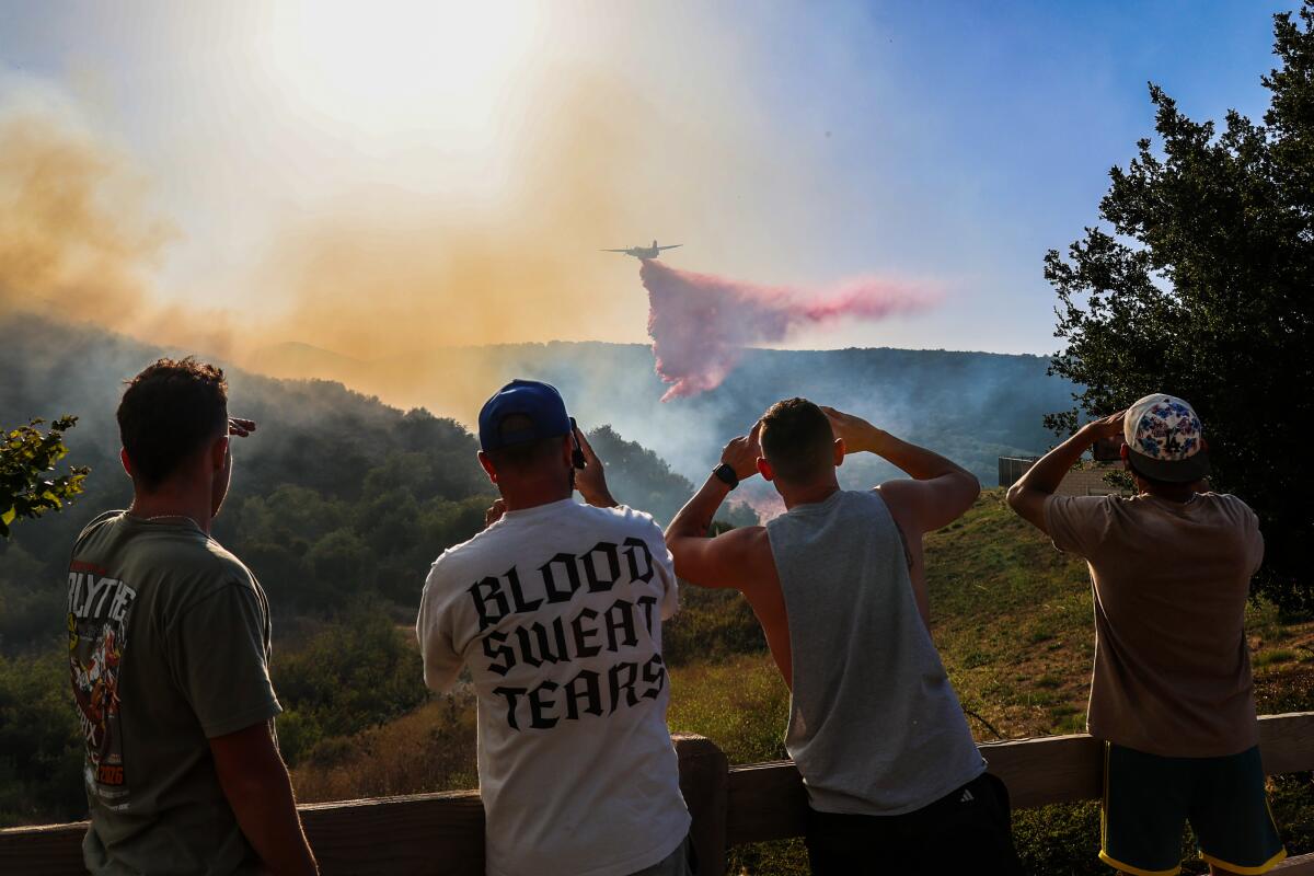 Residents look on as a fire burns in Runkle Canyon