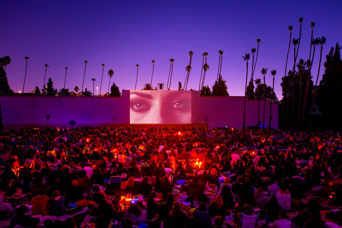 People watch a movie from the lawn of Hollywood Forever Cemetery